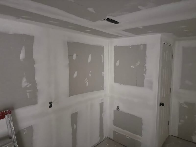 Drywall taping and mudding in progress on a basement job by Home Finishing Inc.